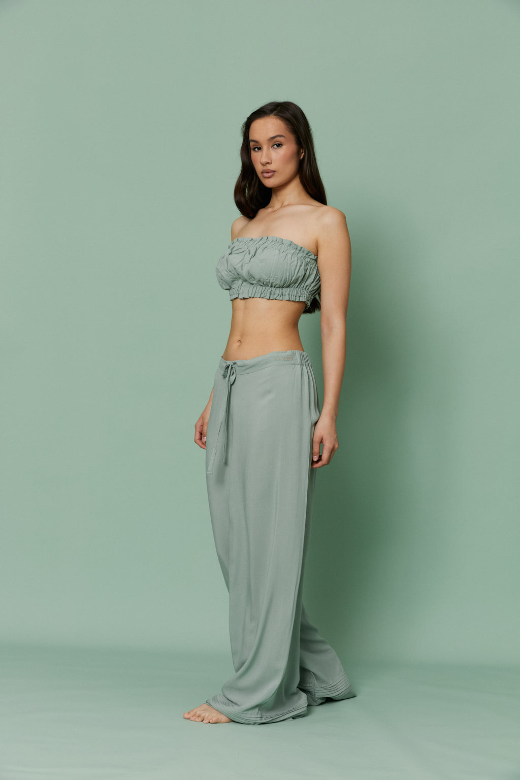 Side profile of model in Azalea Green Voile Lounge Bottom with crop top, emphasizing low-rise fit, flowing fabric and effortless luxury loungewear.