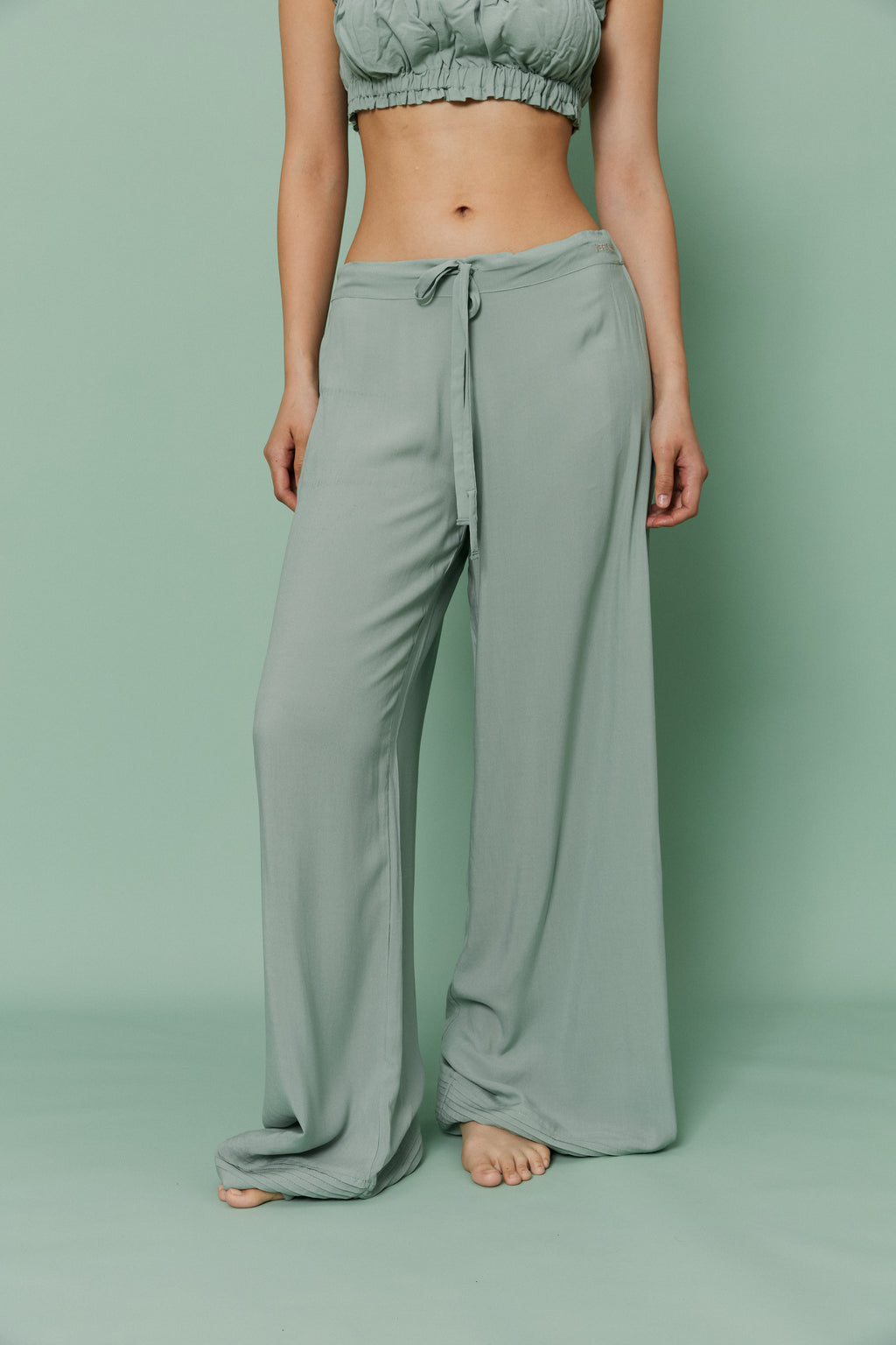 Full-length front view of model standing in Azalea Green Voile Lounge Bottom and matching crop top, featuring relaxed wide-leg silhouette and lightweight voile material.