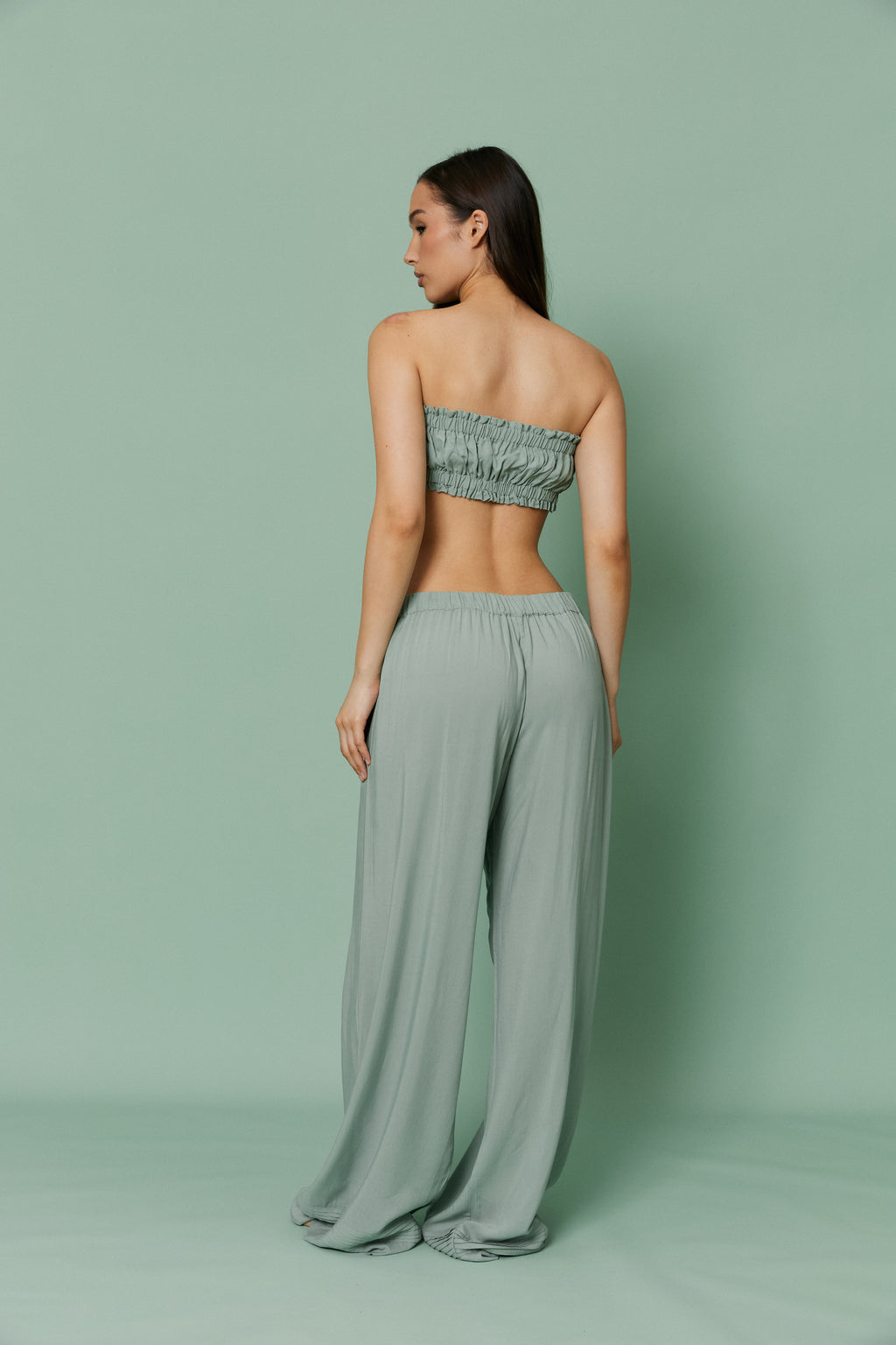 Back full-length view of model in Azalea Green Voile Lounge Bottom with crop top, displaying low-rise waist, soft pleats and breathable sheer voile fabric.