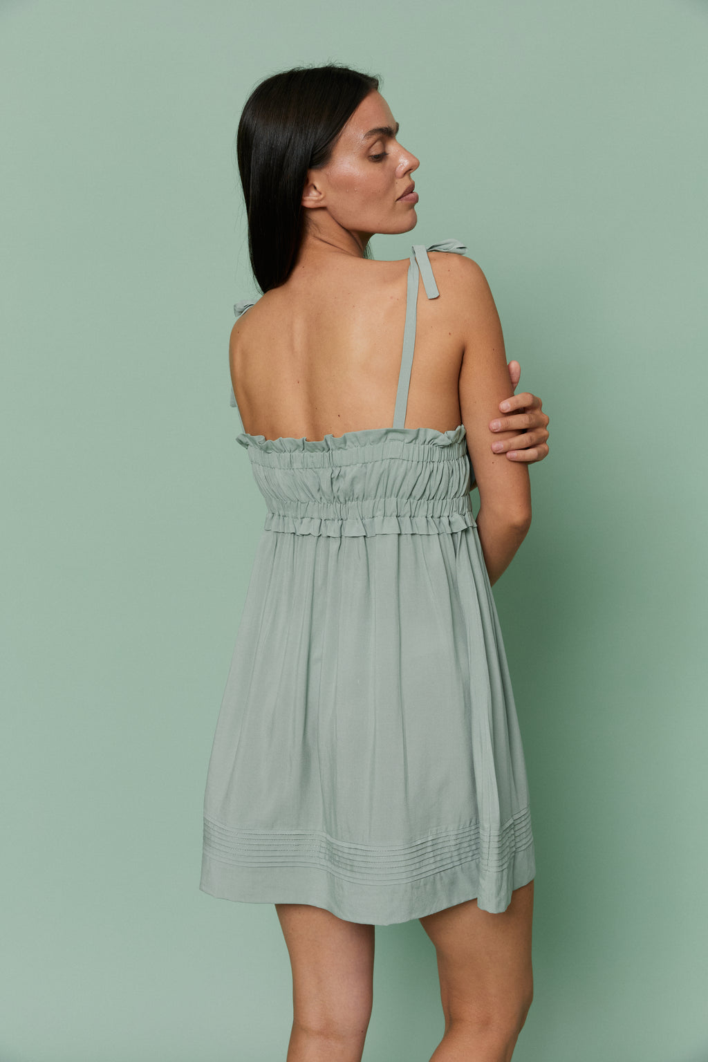 Back view of model wearing Azalea Green Voile Nightdress, featuring ruched bodice, thin tie straps and airy open-back design.