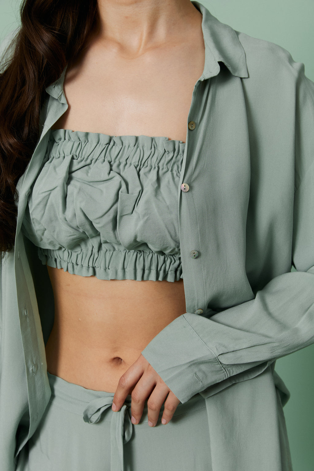 Close-up of model in open Azalea Green Voile Shirt layered over ruched crop top, highlighting breathable sheer voile fabric and relaxed fit.