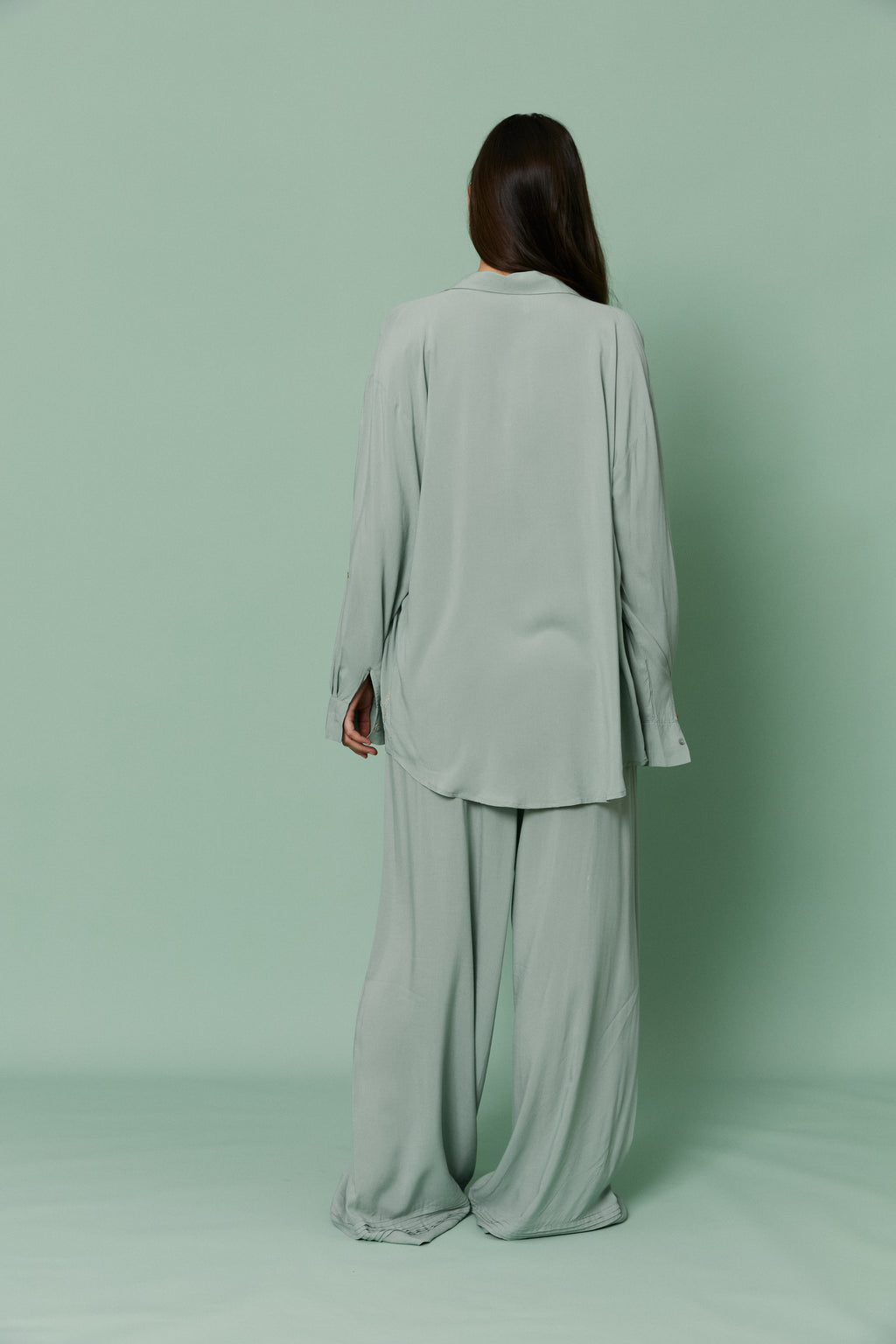 Back full-length view of model in Azalea Green Voile Shirt and matching pants, featuring oversized relaxed fit and lightweight sheer material.