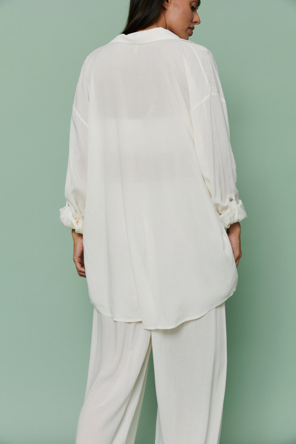Back view of model in Azalea White Voile Shirt and matching pants, displaying relaxed oversized fit and airy lightweight voile material.