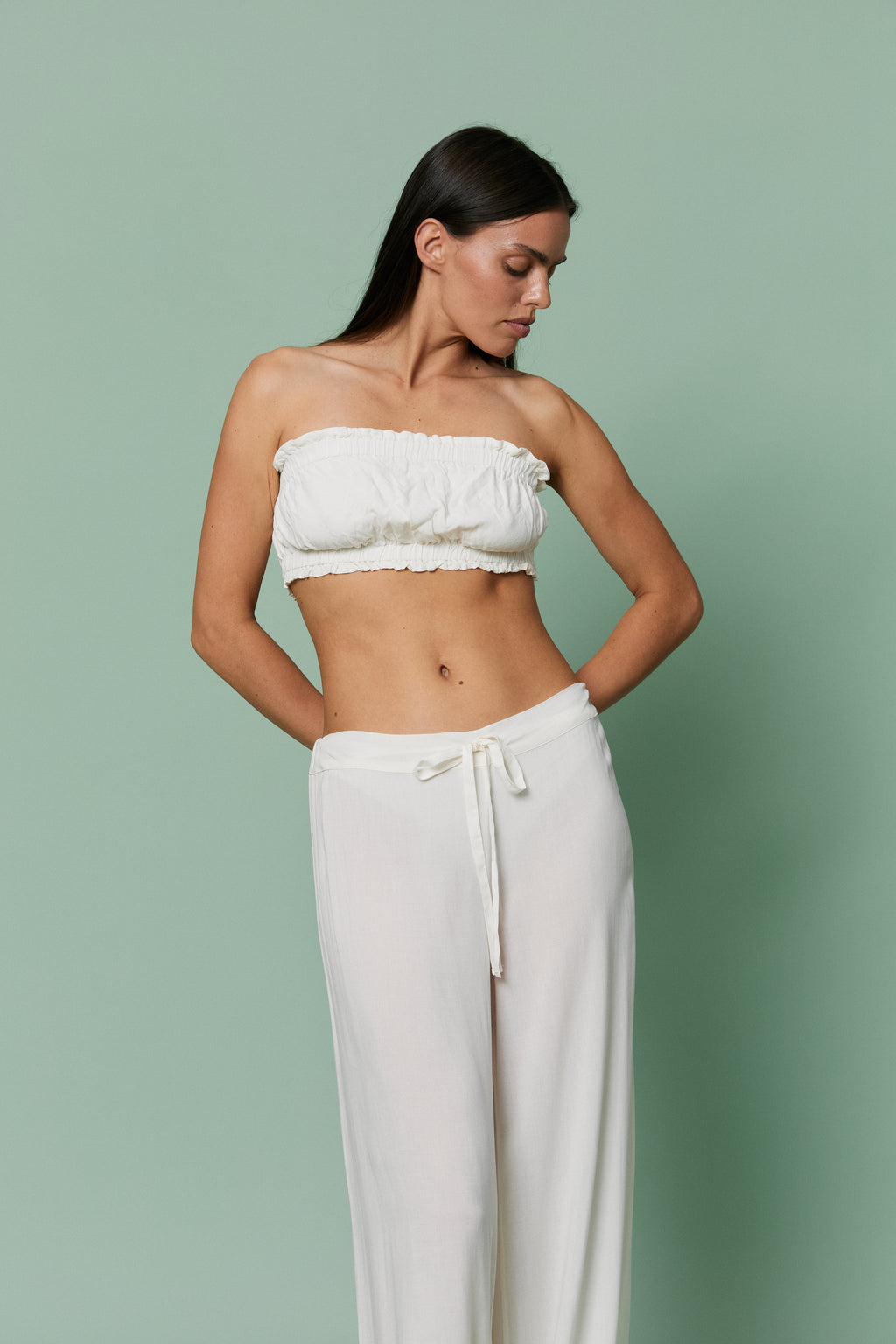 Side profile of model in Azalea White Voile Crop top and pants with hands on hips, emphasizing modern cropped fit and featherlight voile drape.