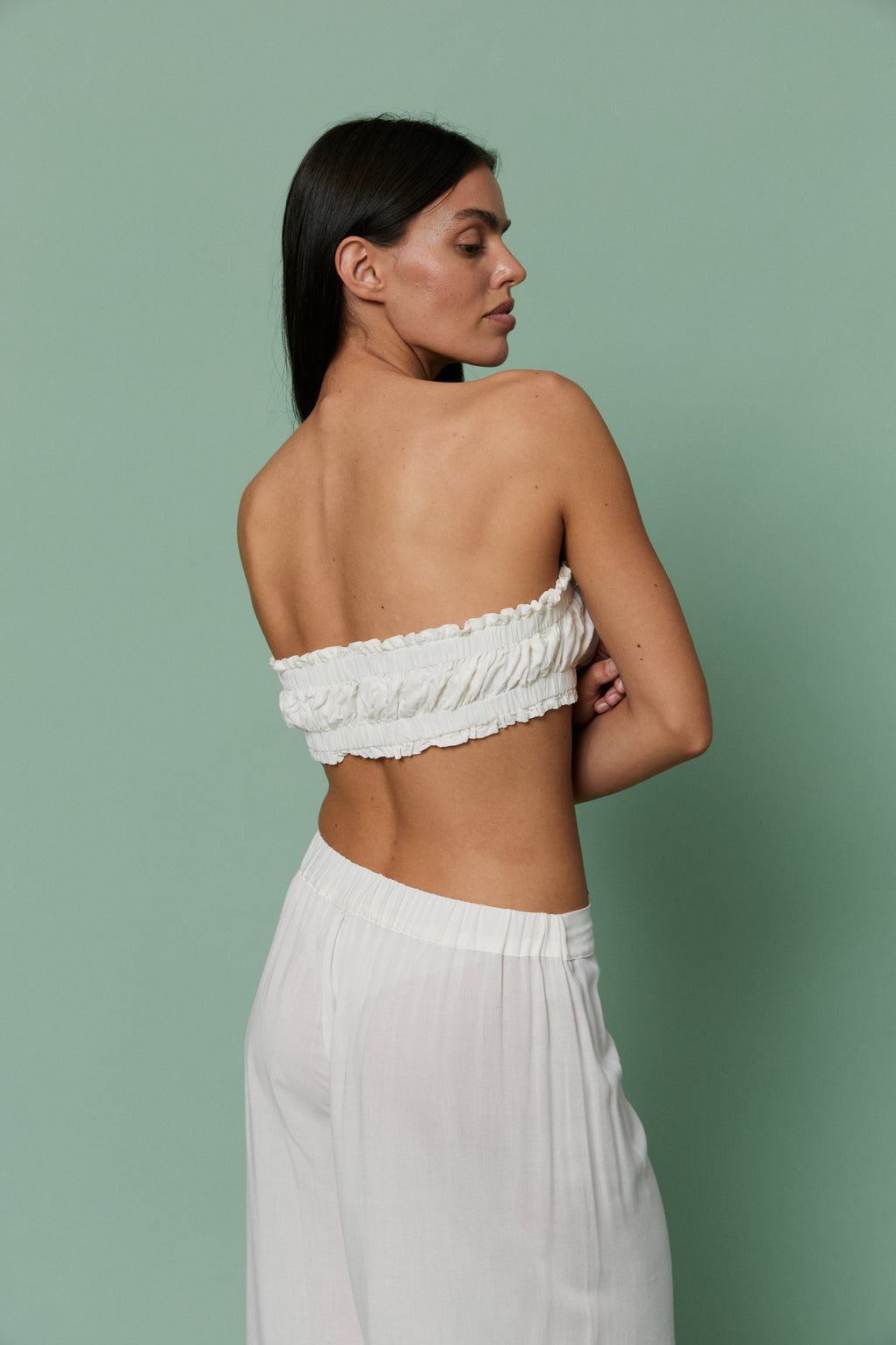 Back three-quarter view of model in Azalea White Voile Lounge Bottom and crop top, highlighting low-rise waist, ruched detailing and lightweight sheer voile fabric.