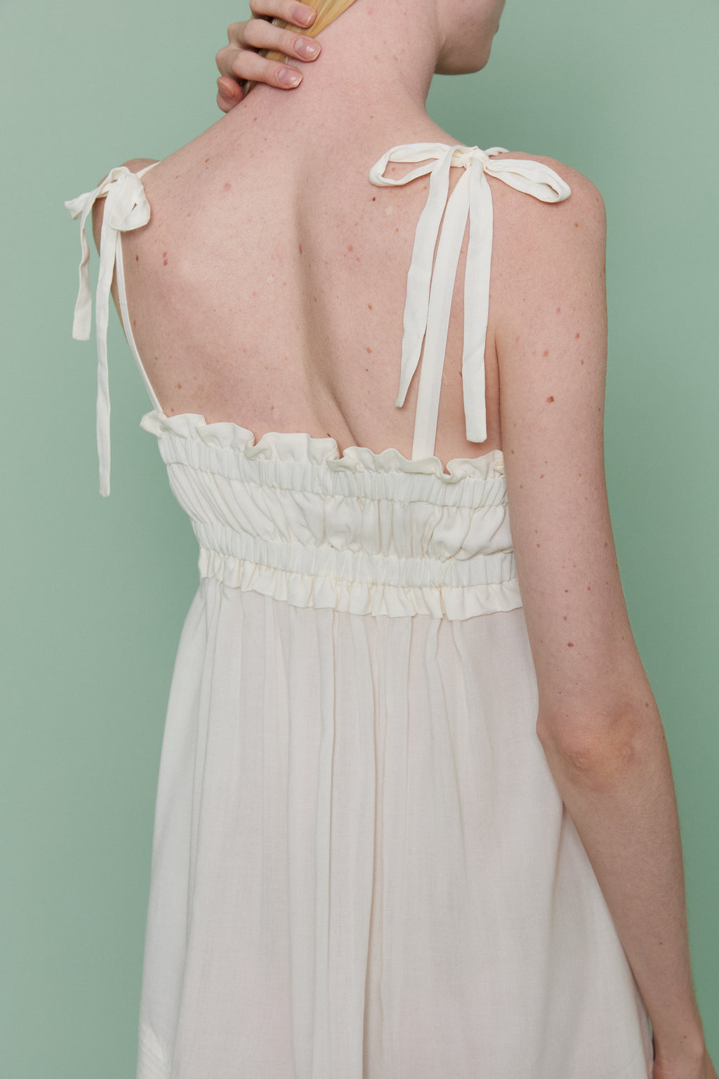 Back view of model in Azalea White Voile Nightdress, highlighting ruched bodice, delicate shoulder tie straps and airy back detail.