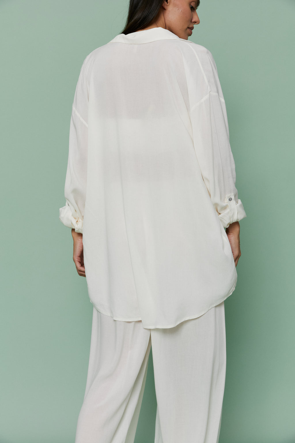 Back view of model in Azalea White Voile Shirt and matching pants, displaying relaxed oversized fit and airy lightweight voile material.