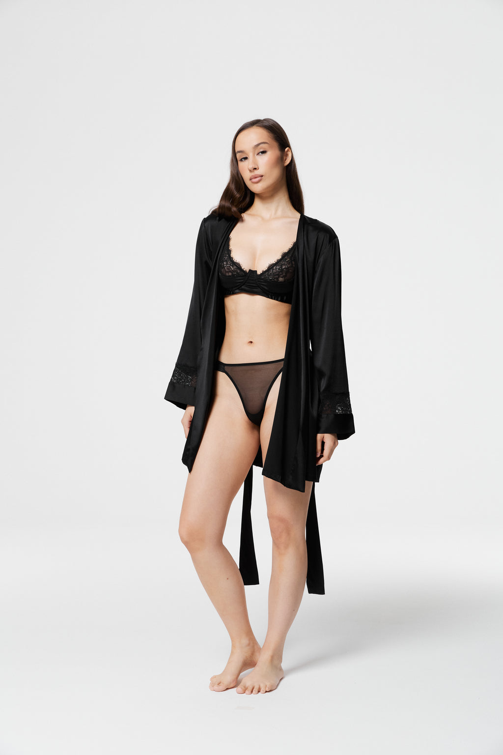 Model posing in open Dicentra Black Silk Robe over black lace lingerie, highlighting lightweight silk fabric and full-length flow.