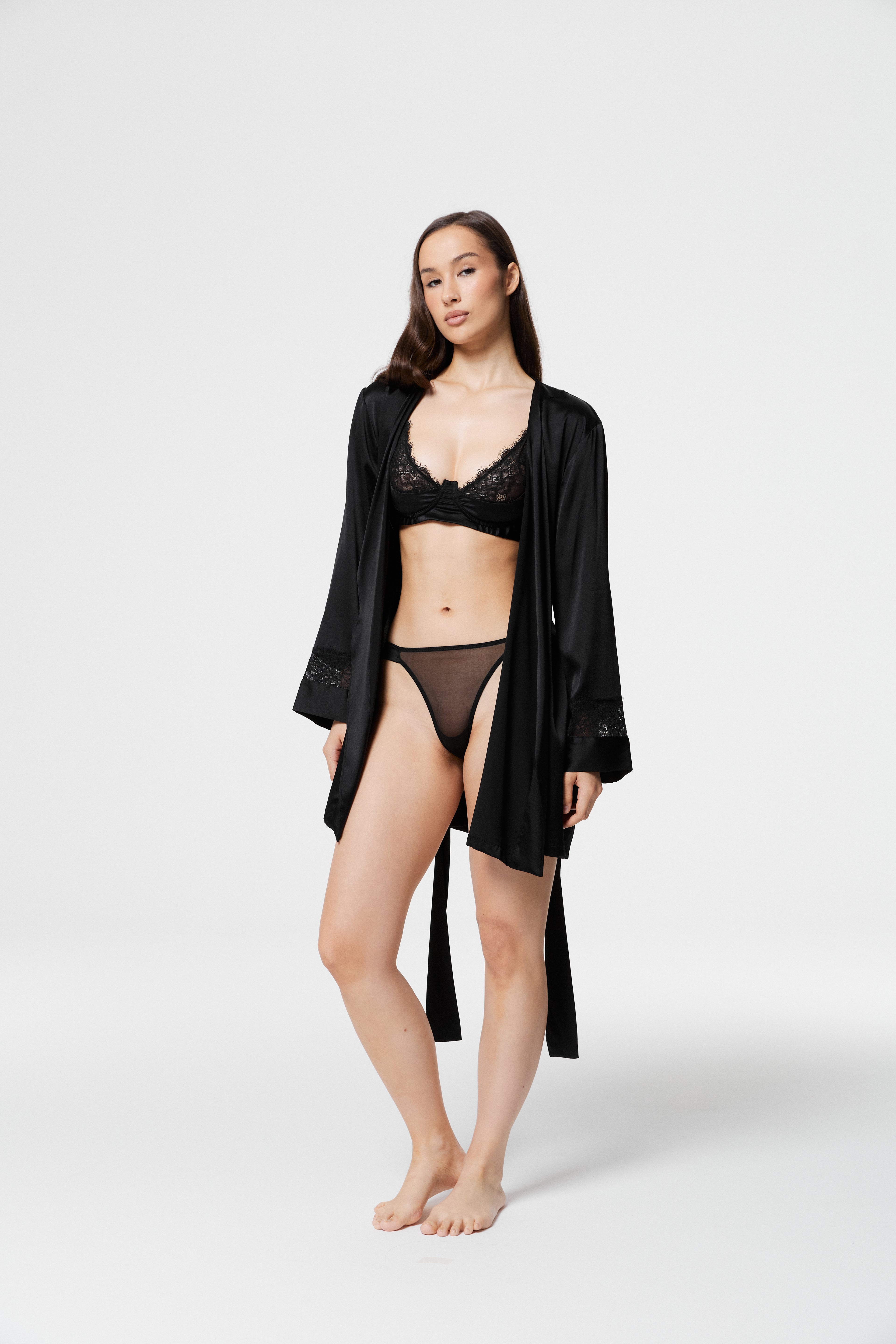 Model posing in open Dicentra Black Silk Robe over black lace lingerie, highlighting lightweight silk fabric and full-length flow.