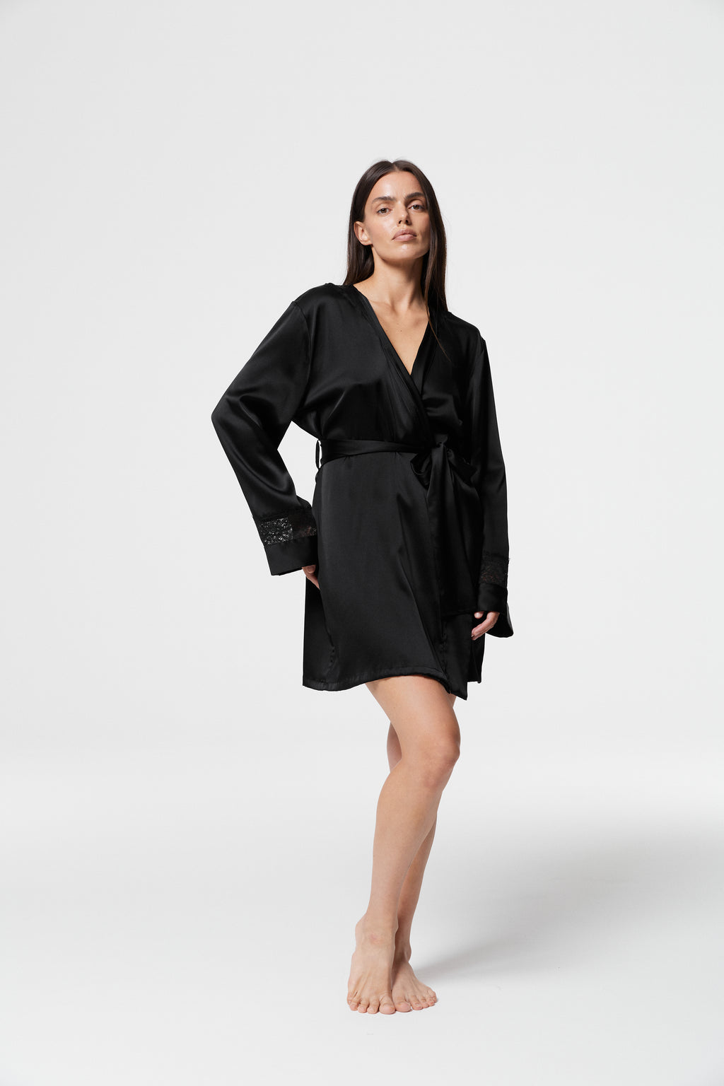 Model standing in closed Dicentra Black Silk Robe with V-neckline, waist tie and relaxed fit in luxurious black silk.